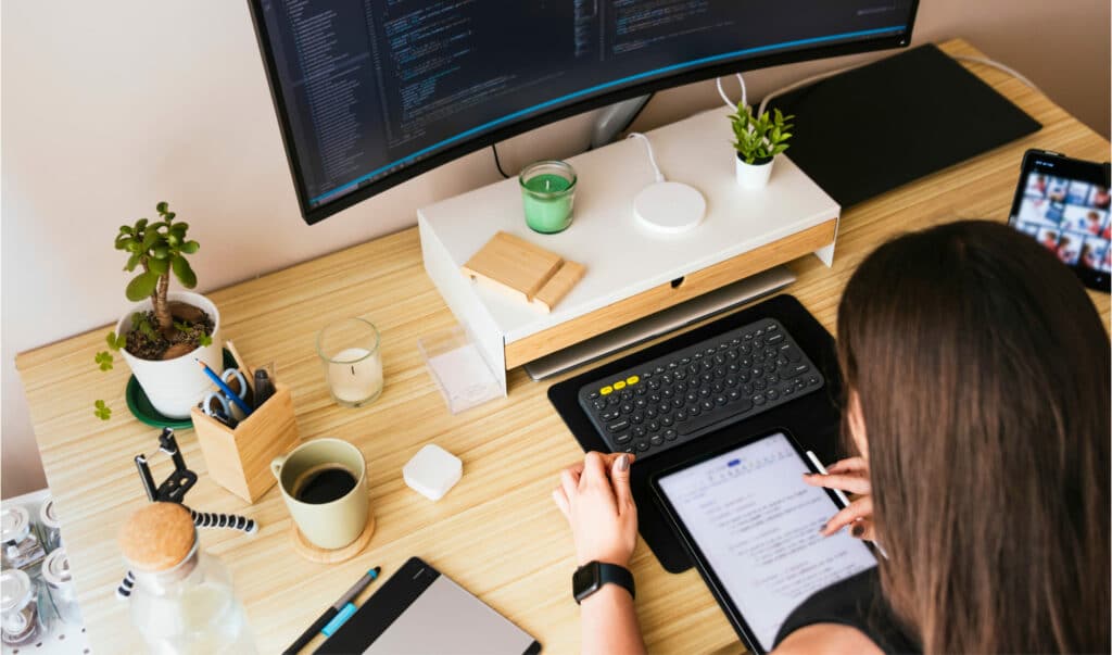 femme consultant une tablette sur son bureau avec ordinateur